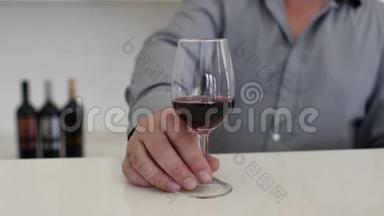 一个人把酒从瓶子里倒进杯子里